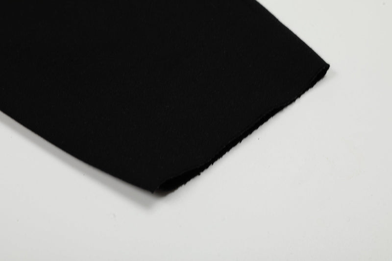 Close-up of black hoodie sleeve cuff on white background