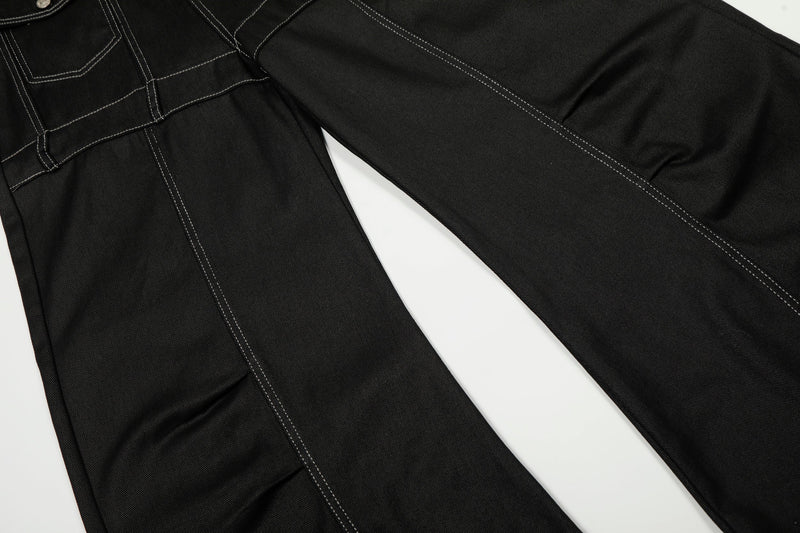 Partial view of black barrel-leg denim pants showing upper front and wide legs