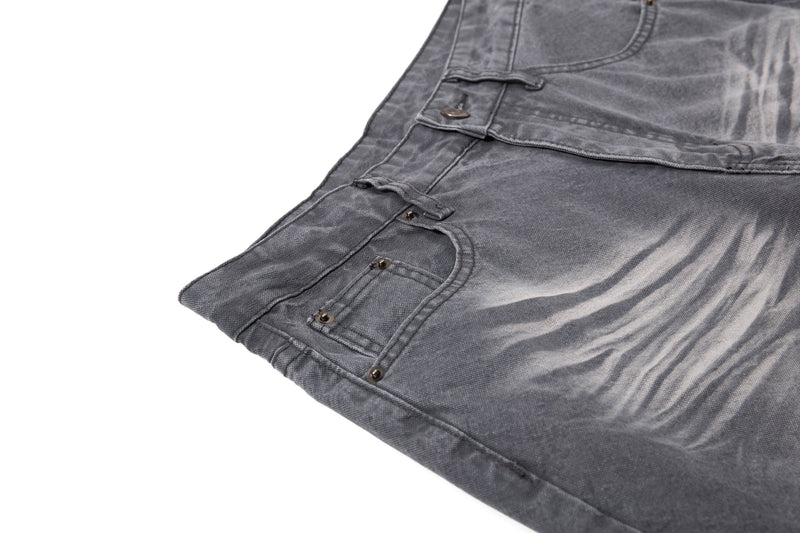 Close-up of charcoal denim front pocket and faded wash detail