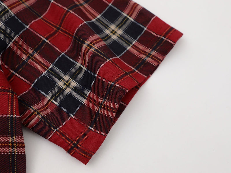 Red and black plaid shirt sleeve with folded cuff and visible tartan pattern on white background