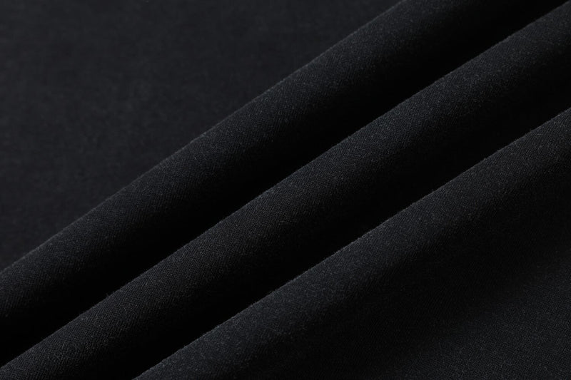 Close-up of black distressed t-shirt fabric with soft folds and a textured streetwear look
