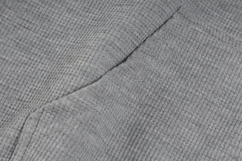 Close-up of gray hoodie fabric with waffle texture and seam detail