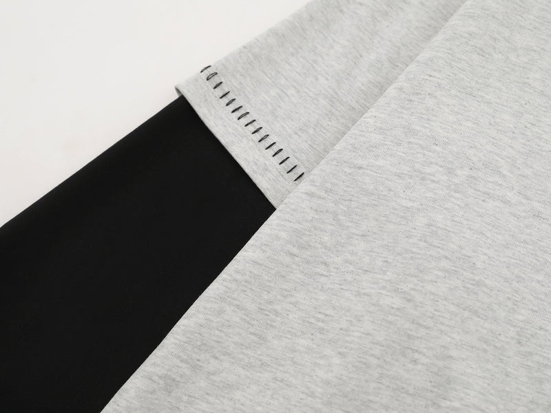 Close-up of heather gray sleeve cuff with black contrast stitching and black underlayer