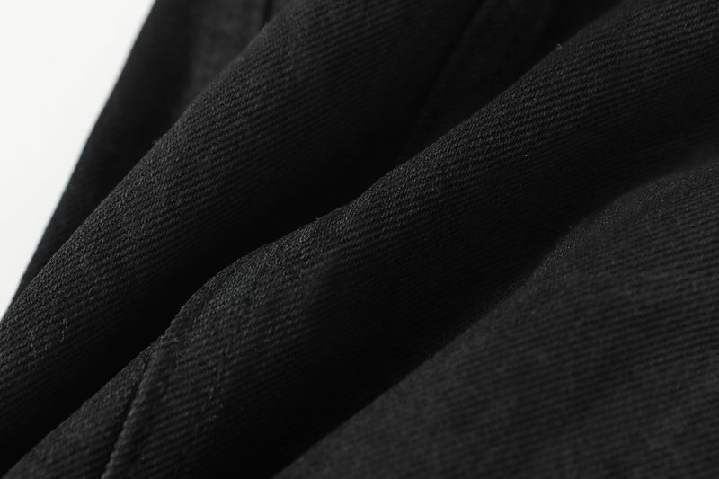 Close-up of black denim fabric showing diagonal weave texture