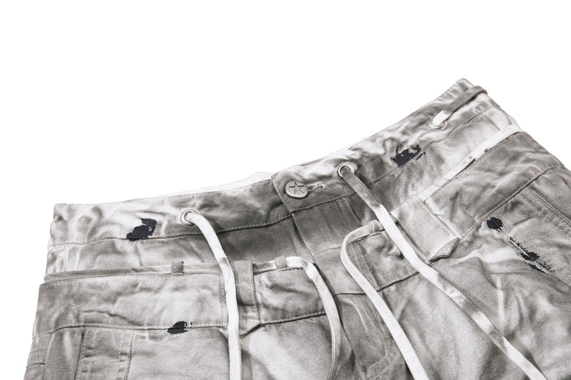 Angled close-up of waistband and drawstring on gray dirty wash jeans