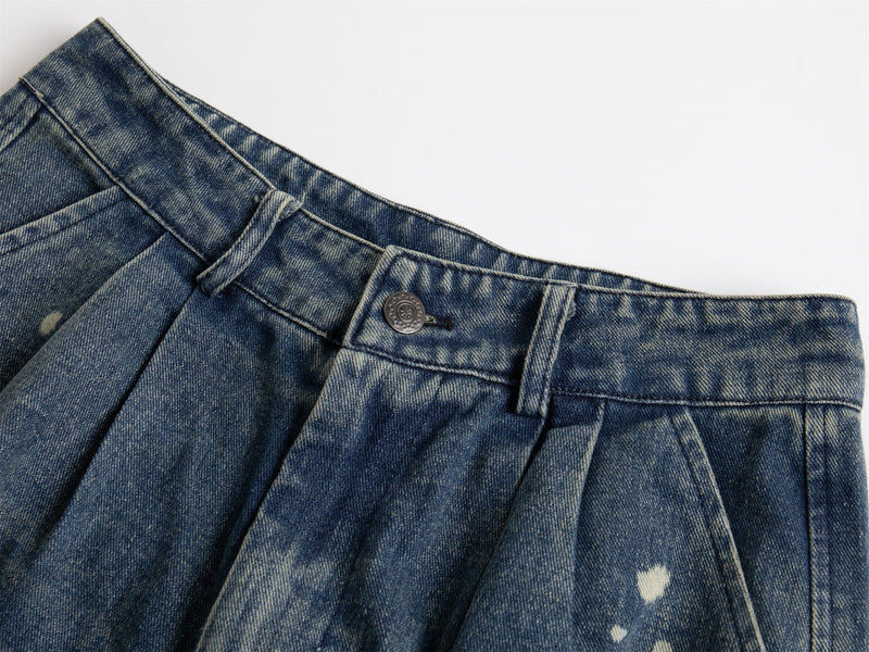 Close-up of denim waistband with belt loop, front button, and faded blue wash