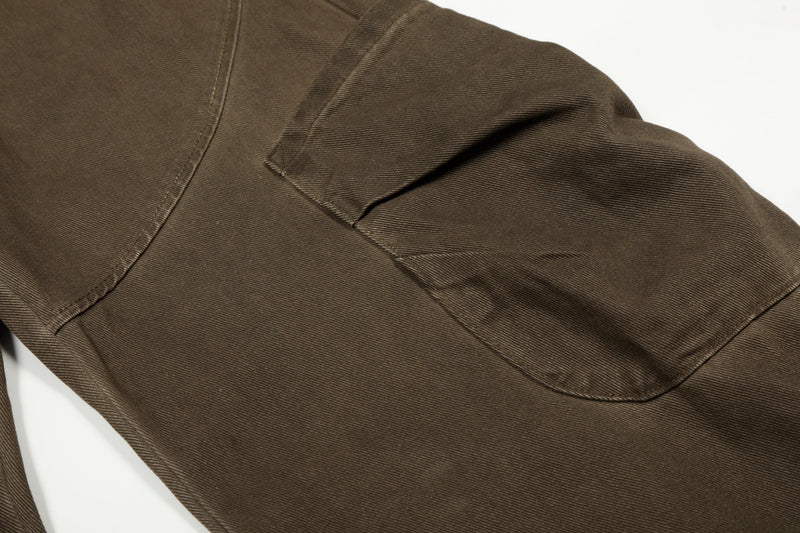 Close-up of brown cargo pants back pocket and curved seam detail
