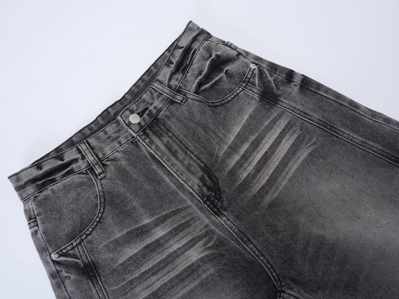 Close-up of grey denim waistband and button closure with faded wash details