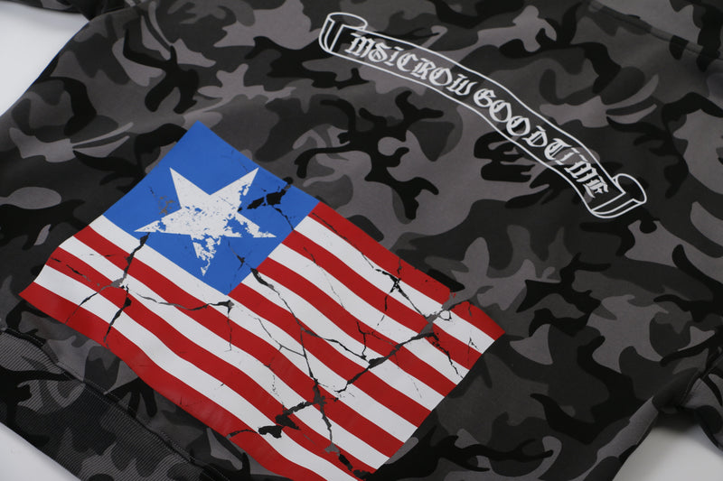 Close-up of back graphic with flag print and curved white logo on black camo hoodie