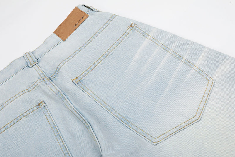 Rear pocket close-up on light wash jeans with leather label at the waistband