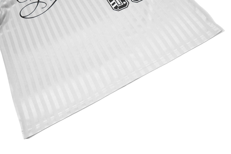 White striped football jersey fabric with stitched hem and bold black script detail on a clean white background