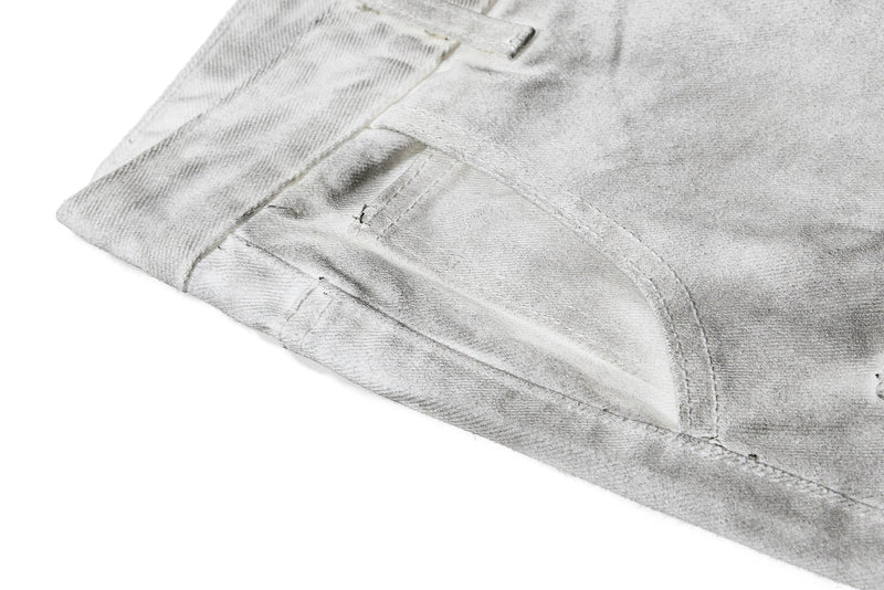 Close-up of light gray flare hem with faded denim texture