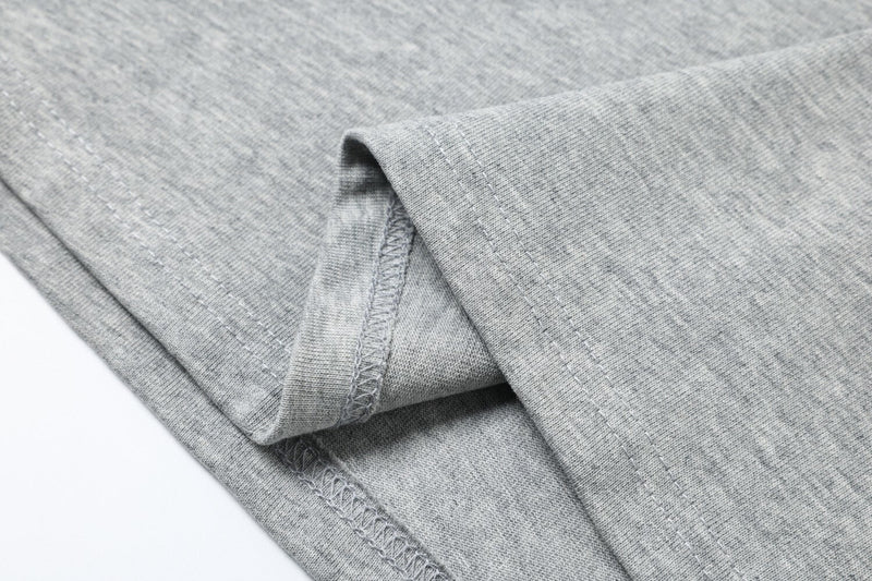 Close-up of gray sleeve seam and stitching detail on the layered tee