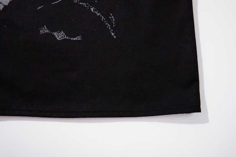 Black button-up shirt hem with subtle distressed graphic print on lightweight streetwear fabric