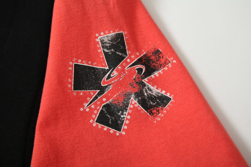 Red crop tee sleeve with black distressed graphic patchwork print in an underground streetwear style