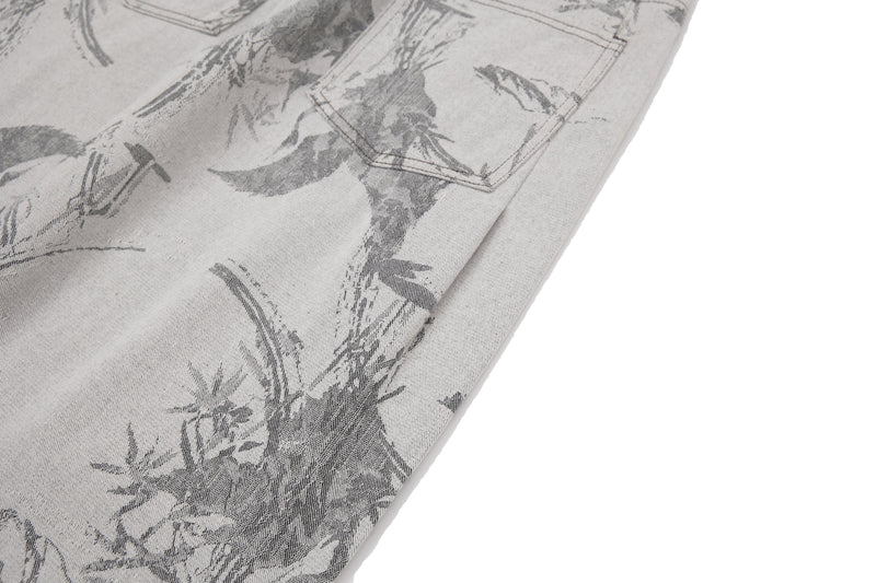 Close-up of one printed pant leg on gray abstract brushstroke denim