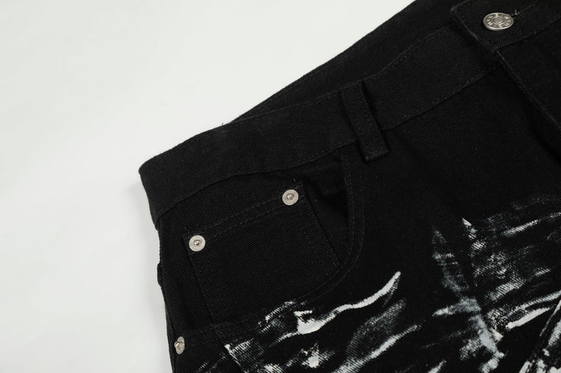 Close-up of black denim pocket and waistband with button rivets and painted print