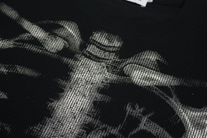 Close-up of a black streetwear tee with bold white skeleton ribcage graphic print