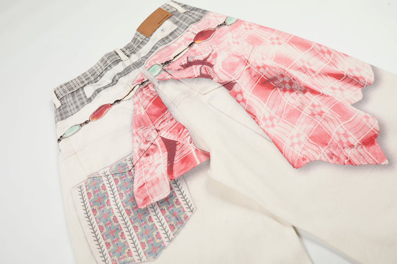Angled close-up of layered pink and cream wide-leg denim pants with printed side pocket