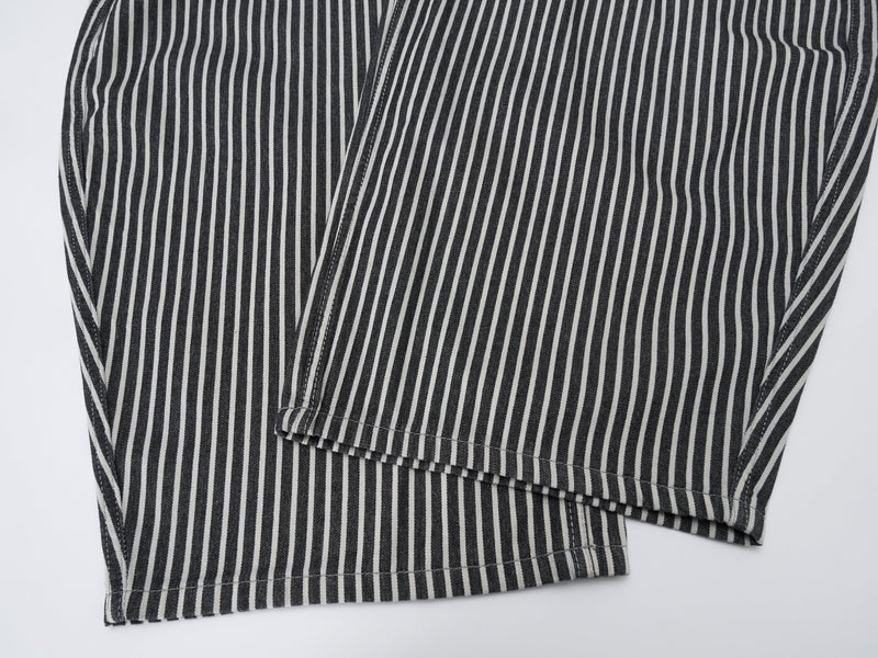 Close-up of striped jeans leg hems laid flat with wide barrel cut