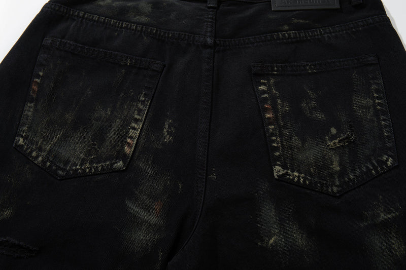 Back view close-up of jeans pockets with paint-wash distressing and ripped details
