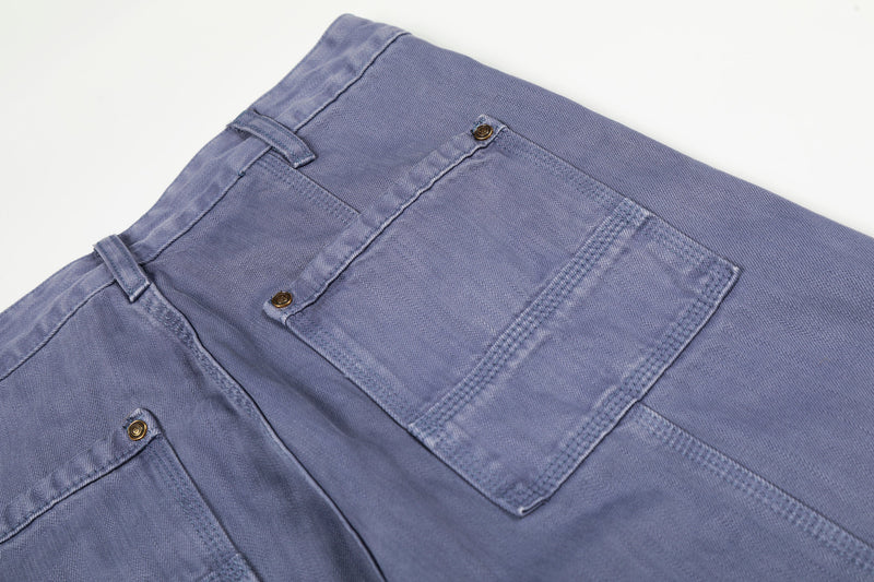 Close-up of back pockets and waistband on blue denim workwear pants