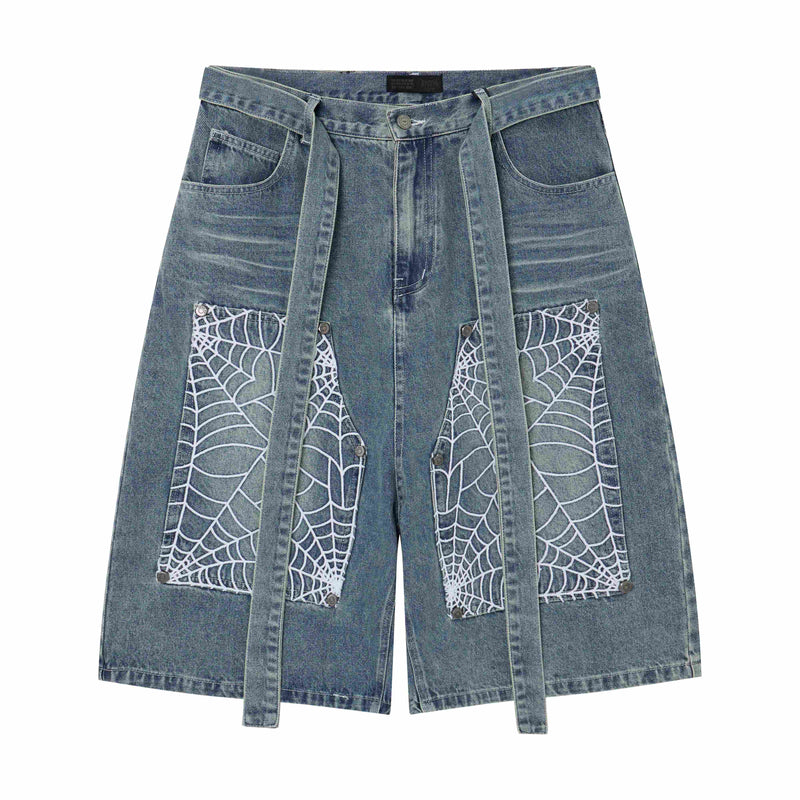Front of light wash denim shorts with hanging straps and white spiderweb pocket panels