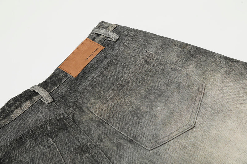 Back waistband detail with tan leather patch and rear pocket on washed denim pants