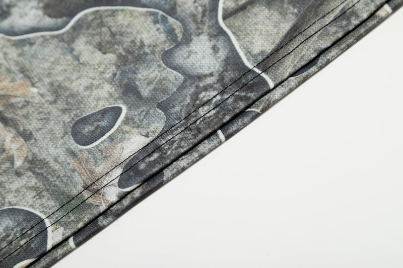 Close-up of hem stitching on camouflage mesh jersey