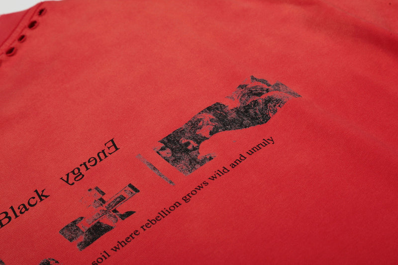 Close-up of a vintage red graphic tee with distressed black text and worn print details