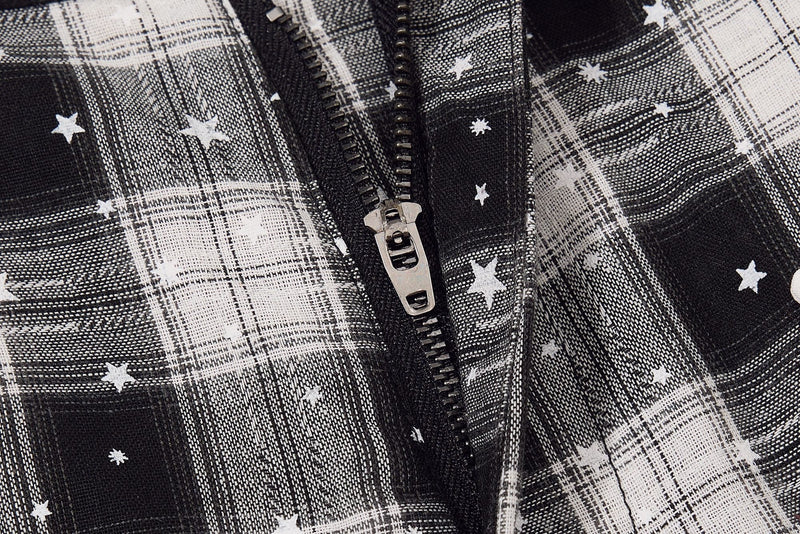 Close-up of front zipper on black and white plaid cargo shorts with star print