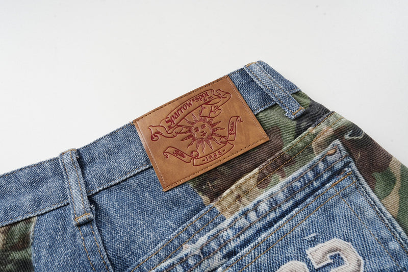 Back waist close-up with tan Sparrow Spot patch on blue denim and camouflage jorts