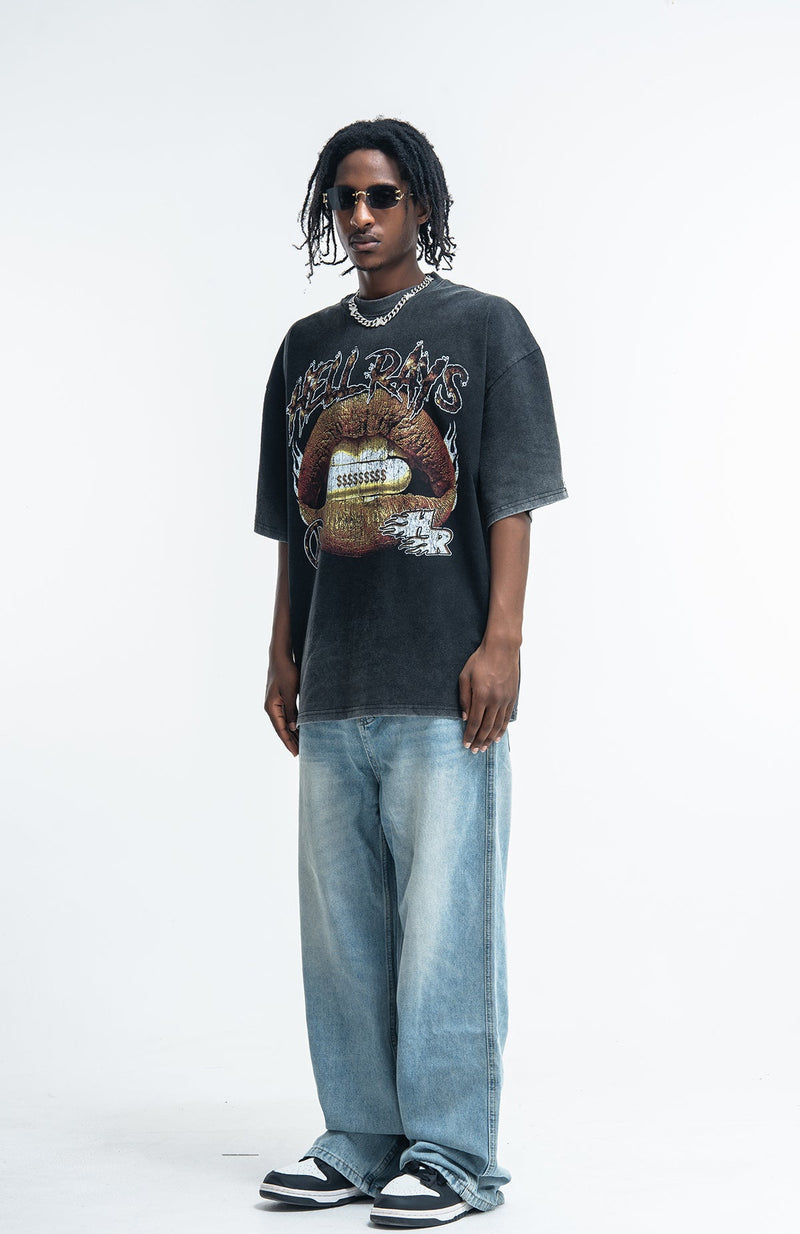 Model wearing a vintage washed black Seakoff Hellrays graphic tee with oversized faded jeans and sneakers