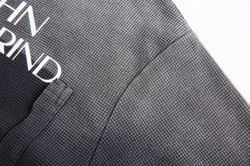 Close-up of black and gray waffle knit shoulder seam on long sleeve tee