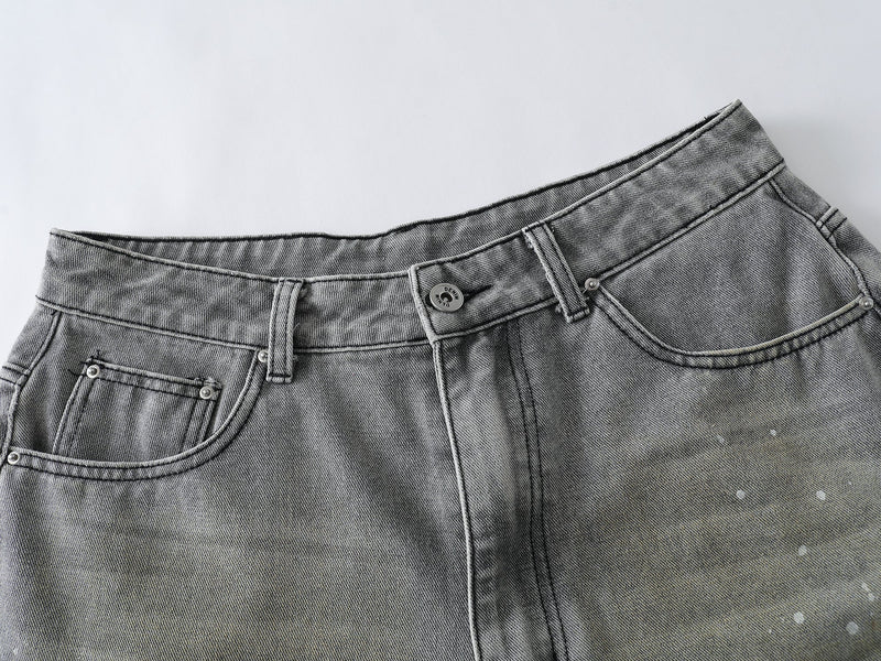 Front top section of grey wash denim shorts showing the waistband, button fly, and curved pockets