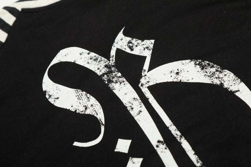 Close-up of distressed gothic cross graphic printed on black tee