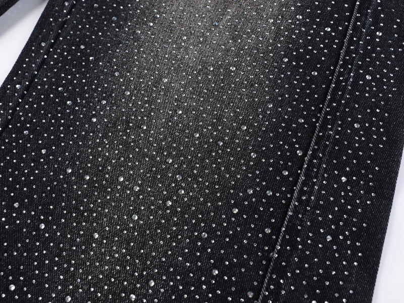 Black denim leg close-up covered in dense rhinestone speckles