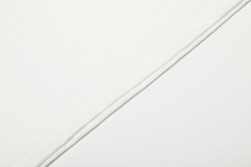 Close-up of white tee sleeve fabric with smooth stitched seam