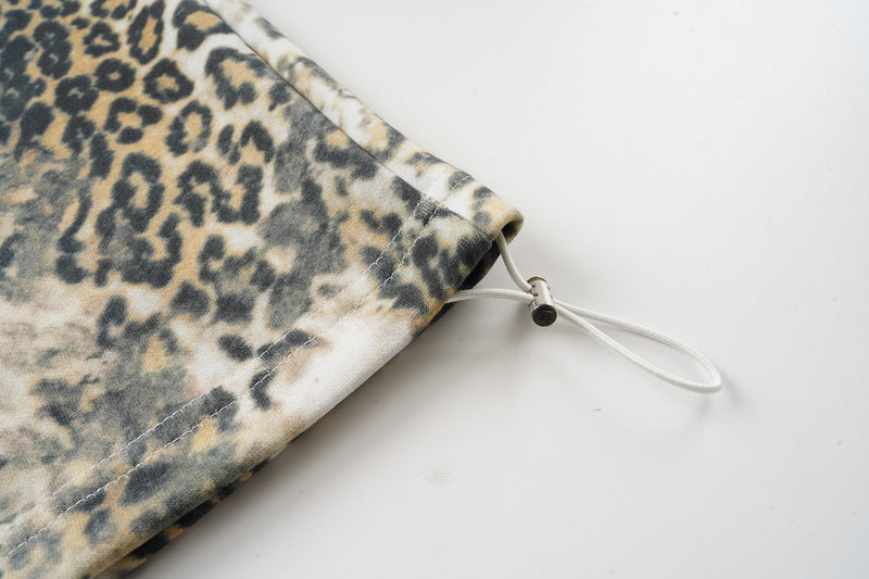 Close-up of pant cuff with drawcord toggle and stitched hem