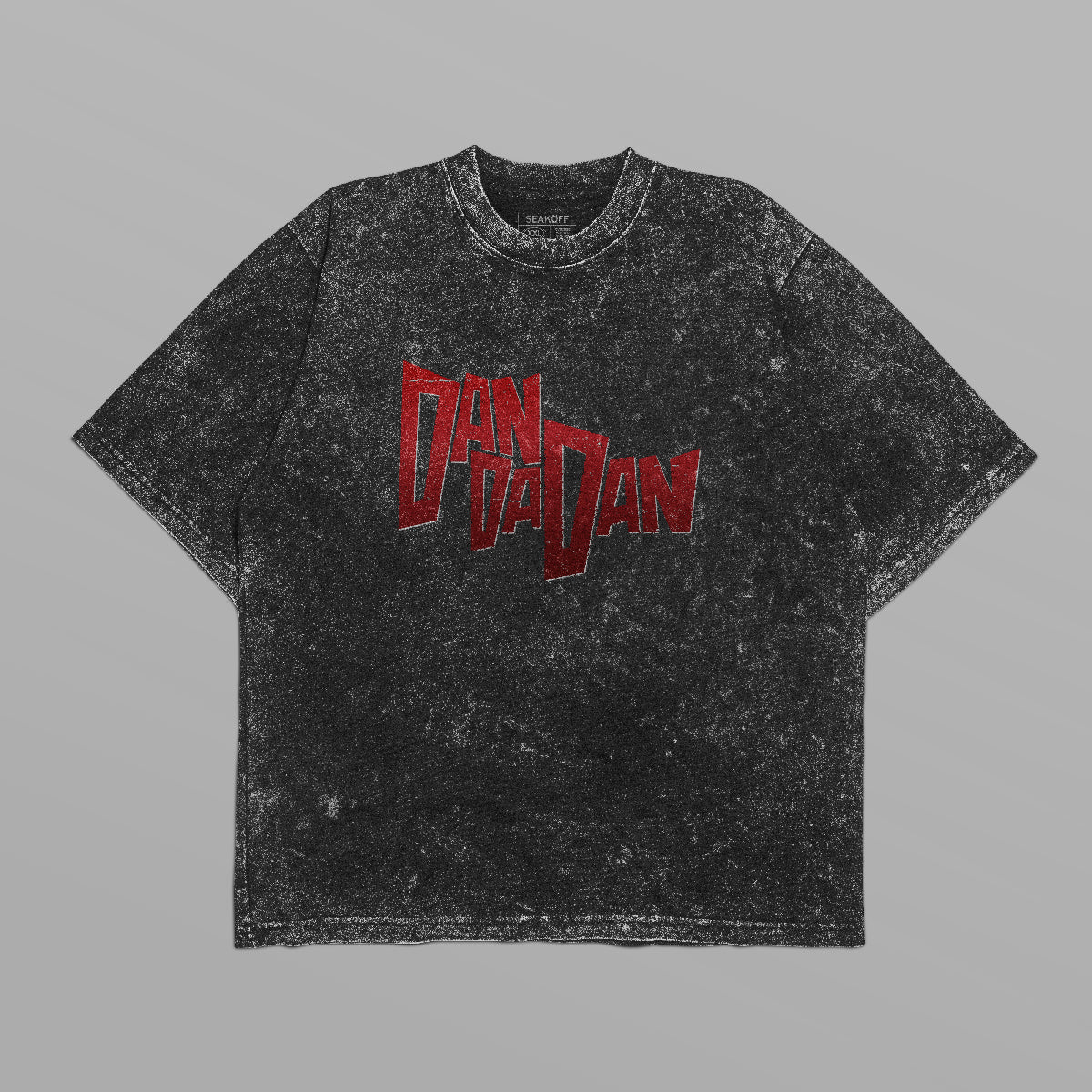 The Dandadan Oversized T-Shirt features a bold red “DAN DA DAN” graphic on acid-wash black, perfect for anime streetwear fans. Made from 250 GSM cotton, it has an oversized fit, short sleeves, and a round neckline. Ideal for standout style against gray backdrops.