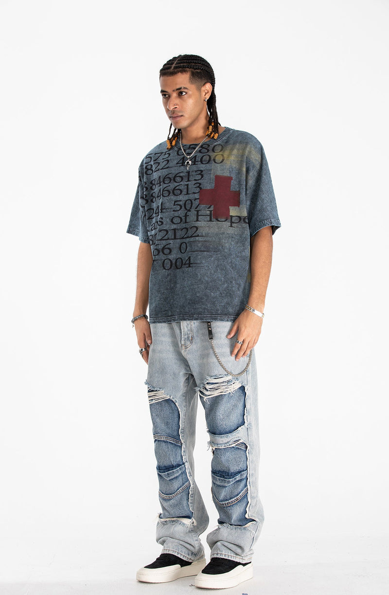 Vintage wash oversized graphic tee with faded numbers, red cross print, and relaxed streetwear style