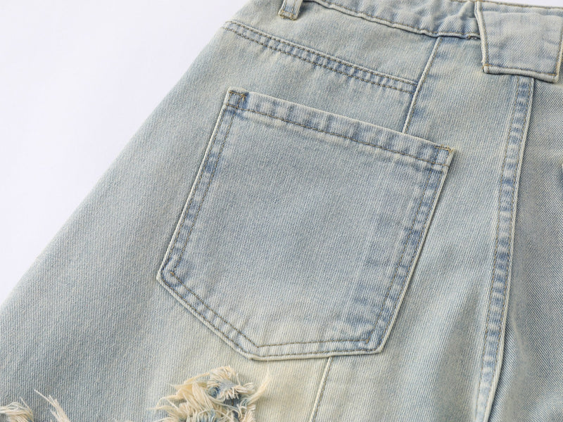 Close-up of the back pocket on light wash distressed wide-leg jeans