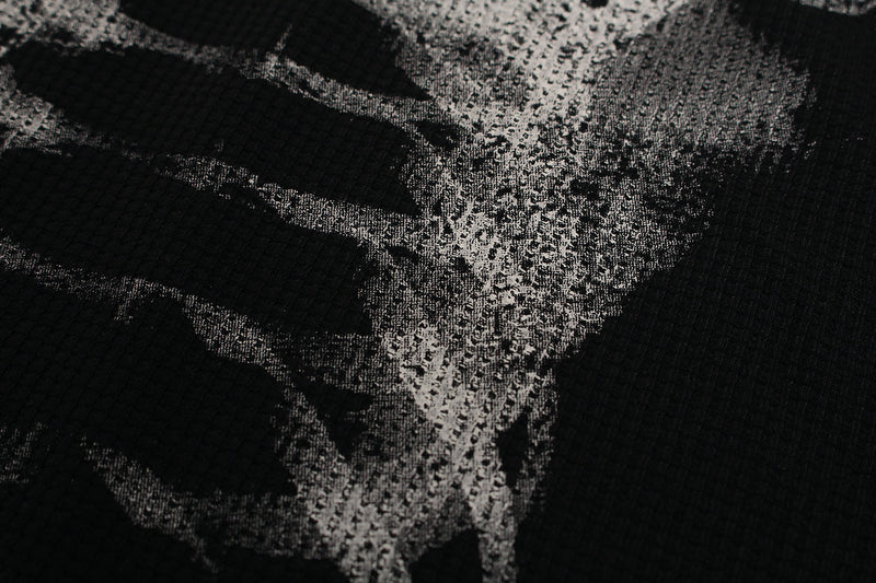 Close-up of black tee front print showing spine and rib bones in white