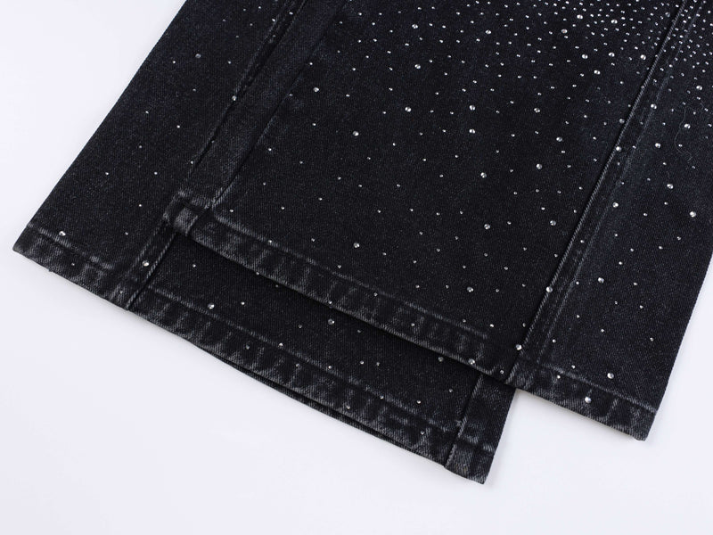 Black denim hem close-up with rhinestone speckles and folded cuff