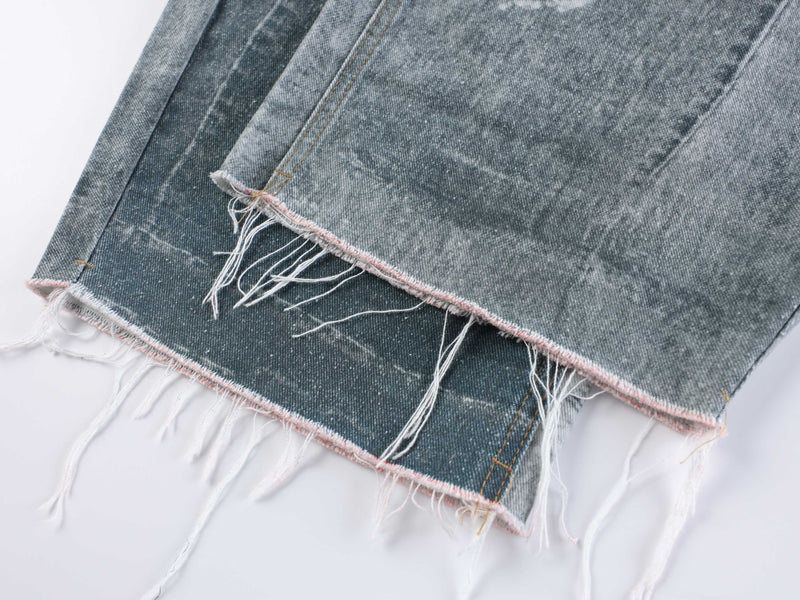 Frayed hem close-up on faded wide leg denim jeans