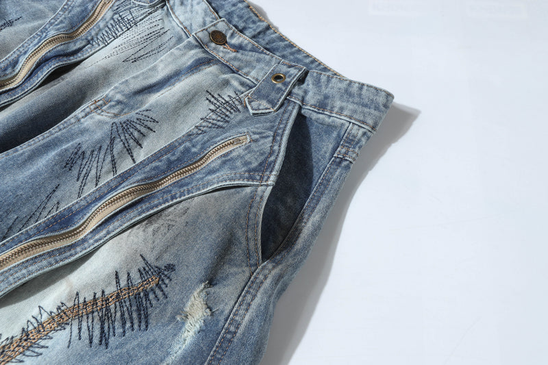 Close-up of front zip pocket and seam details on patchwork wide-leg jeans