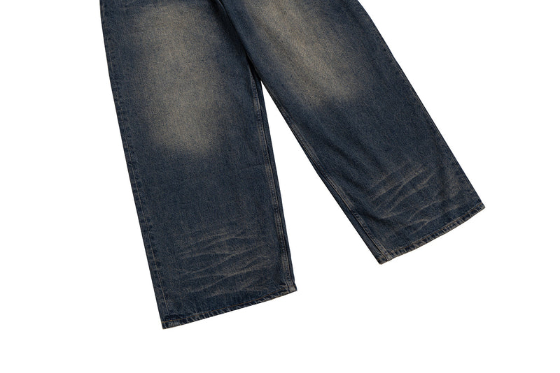 Lower legs of wide-leg blue denim jeans with faded creasing near the hems