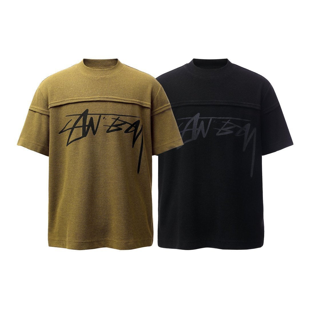 Omirad Script Logo Waffle T-Shirt in olive and black colorways, front view showing panel seam and handwritten logo print