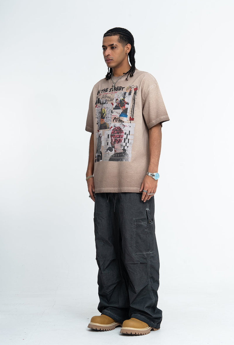 Model wearing a vintage wash beige graphic tee with collage print, paired with loose black cargo pants and tan boots