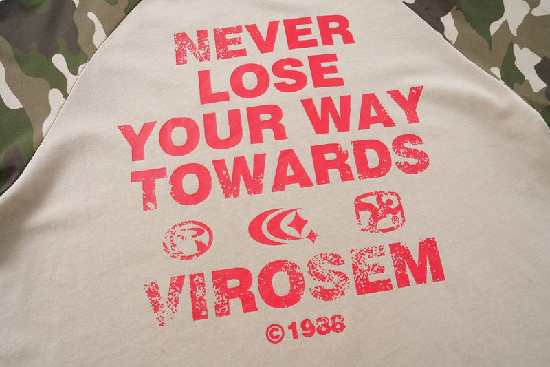 Camo raglan T-shirt with bold red Never Lose Your Way print on beige fabric, close-up streetwear graphic detail